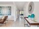 Hallway with modern decor leading to a dining area, wood accent table, and tile flooring at 3850 Royal Azalea Way, Sanford, FL 32773