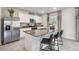 Open kitchen featuring a granite island with seating, stainless steel refrigerator, and bright white cabinets at 3850 Royal Azalea Way, Sanford, FL 32773