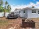 View of backyard with new fencing, trees and shrubs. Trailer parked by the side of the house at 398 Rose St, Umatilla, FL 32784