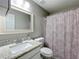 Cozy bathroom features patterned shower curtain and granite counters at 398 Rose St, Umatilla, FL 32784