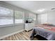 Bedroom featuring windows with blinds, a bed, and dresser with TV at 398 Rose St, Umatilla, FL 32784