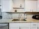 Close-up view of the kitchen sink, granite countertops, and white cabinets at 398 Rose St, Umatilla, FL 32784