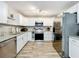 Bright kitchen features stainless steel appliances, granite countertops, and white cabinets at 398 Rose St, Umatilla, FL 32784