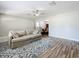 Bright and open living space with a comfortable sofa, ceiling fan, and seamless flow to other rooms at 398 Rose St, Umatilla, FL 32784