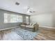 Comfortable living room with wood-look floors, a cozy sofa, and a large window for natural light at 398 Rose St, Umatilla, FL 32784