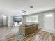 Bright living room with wood-look floors, a comfortable sofa, and a large window offering natural light at 398 Rose St, Umatilla, FL 32784