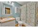Bathroom with blue walls featuring a vanity, toilet, shower/tub combo, and storage at 5102 Monticello Heights Ln, Oviedo, FL 32765