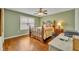 Cozy bedroom features a decorative metal frame bed, ceiling fan, and hardwood floors at 5102 Monticello Heights Ln, Oviedo, FL 32765