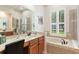 A bright bathroom with a soaking tub, glass enclosed shower, and double vanity at 530 Heatheroak Cv, Altamonte Springs, FL 32714