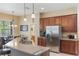 An open kitchen with stainless steel appliances, wood cabinets and granite countertops that open to the dining room at 530 Heatheroak Cv, Altamonte Springs, FL 32714