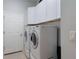 A Laundry Room with a washer, dryer, white cabinets, and a door at 530 Heatheroak Cv, Altamonte Springs, FL 32714