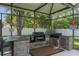This outdoor kitchen features a built-in grill, bar seating, and a screened enclosure at 530 Heatheroak Cv, Altamonte Springs, FL 32714