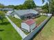 Aerial view of the fenced backyard with a screened lanai and a storage shed at 5583 Miles Dr, Port Orange, FL 32127