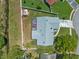 This aerial view shows a home with an enclosed patio, fenced yard and a shed next to a canal at 5583 Miles Dr, Port Orange, FL 32127