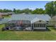 Aerial view of the home showcasing the screened lanai, patio furniture, and spacious backyard at 5583 Miles Dr, Port Orange, FL 32127