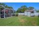 Backyard featuring a screened-in lanai with patio furniture and a storage shed at 5583 Miles Dr, Port Orange, FL 32127
