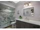 Modern bathroom featuring a glass shower with seat, gray vanity with stone countertop at 5583 Miles Dr, Port Orange, FL 32127