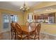 Dining room with table and six chairs plus decorative chandelier and view of kitchen at 5583 Miles Dr, Port Orange, FL 32127