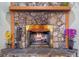 Stone fireplace with wooden mantle and hearth, plus glass doors. Fire is burning inside at 5583 Miles Dr, Port Orange, FL 32127