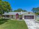 Charming single-story home with a well-manicured lawn and two-car garage at 5583 Miles Dr, Port Orange, FL 32127