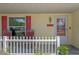 Close-up of the cozy front porch with chairs and a decorative picket fence at 5583 Miles Dr, Port Orange, FL 32127