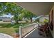Covered front porch with seating area and view of the well-maintained front yard at 5583 Miles Dr, Port Orange, FL 32127