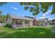 Charming single-story home with red accents, a well-manicured lawn, and a white picket fence at 5583 Miles Dr, Port Orange, FL 32127