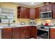 Kitchen with stainless steel appliances, cherry cabinets, and granite countertops at 5583 Miles Dr, Port Orange, FL 32127