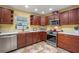 Kitchen with stainless steel appliances, cherry cabinets, and granite countertops at 5583 Miles Dr, Port Orange, FL 32127