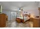 This main bedroom boasts a four-poster bed, ceiling fan, and tiled floors at 5583 Miles Dr, Port Orange, FL 32127