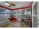 Bright sunroom with tile flooring, windows offering backyard views, and neutral-toned furniture at 5583 Miles Dr, Port Orange, FL 32127