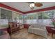 Bright sunroom with lots of windows, tile flooring, comfortable seating, and red accent walls at 5583 Miles Dr, Port Orange, FL 32127