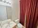Functional bathroom showcasing a vanity with a sink, toilet, and a patterned privacy curtain at 5615 Oxford Moor Blvd, Windermere, FL 34786