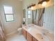 Bathroom features a double sink vanity with wood cabinets, decorative lighting, and large mirror, offering a functional space at 5615 Oxford Moor Blvd, Windermere, FL 34786