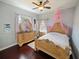 Charming bedroom featuring a decorative bed frame, dresser with mirror, and ample natural light at 5615 Oxford Moor Blvd, Windermere, FL 34786