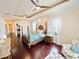 Serene main bedroom boasts hardwood floors, a tray ceiling with ceiling fans, and french doors to lanai at 5615 Oxford Moor Blvd, Windermere, FL 34786