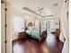 Serene main bedroom boasts hardwood floors, a tray ceiling with ceiling fans, and french doors to lanai at 5615 Oxford Moor Blvd, Windermere, FL 34786