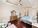 Serene main bedroom boasts hardwood floors, a tray ceiling with ceiling fans, and french doors to lanai at 5615 Oxford Moor Blvd, Windermere, FL 34786