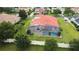 Aerial view of a home featuring a screened-in pool area with a terracotta roof at 5615 Oxford Moor Blvd, Windermere, FL 34786