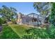 Backyard featuring a screened in pool and lush landscaping on a sunny day at 605 W Palm Valley Dr, Oviedo, FL 32765