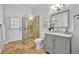Bright bathroom with glass shower enclosure, vanity with grey cabinets, and access to the patio at 605 W Palm Valley Dr, Oviedo, FL 32765