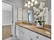 Bathroom with granite countertop, white cabinetry, large mirror, and decorative orchid at 605 W Palm Valley Dr, Oviedo, FL 32765