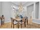Elegant dining room with chandelier, travertine floors, and stately columns at 605 W Palm Valley Dr, Oviedo, FL 32765