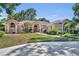 Beautiful home boasts an inviting front exterior, red front door, lush landscaping, and a well-manicured lawn at 605 W Palm Valley Dr, Oviedo, FL 32765