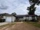 Charming single-story home featuring a well-manicured lawn, solar panels, and an attached garage at 7028 Clarcona Ocoee Rd., Orlando, FL 32818