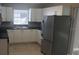 Bright kitchen features modern stainless steel refrigerator, sleek cabinetry, and a window over the sink at 7028 Clarcona Ocoee Rd., Orlando, FL 32818