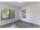 Bedroom featuring neutral white walls, vinyl plank flooring, and bright natural light from two windows at 735 N Clara Ave, Deland, FL 32720