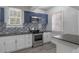 Modern kitchen featuring stainless steel appliances, white cabinets, and granite countertops at 735 N Clara Ave, Deland, FL 32720