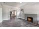 Cozy living room features a brick fireplace, neutral paint and gray wood floors at 735 N Clara Ave, Deland, FL 32720