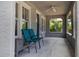 Relaxing covered porch features gray textured walls, tile floor, and ceiling fan at 735 N Clara Ave, Deland, FL 32720